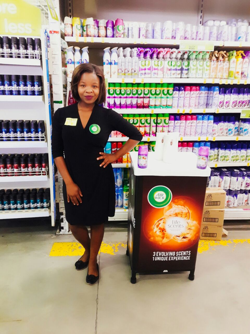 In-store promoter at an Air Wick display in a supermarket aisle